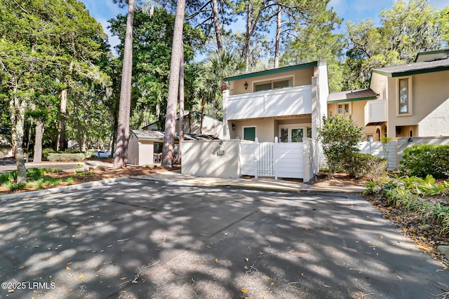 19 Stoney Creek Rd Unit 296, Hilton Head Island, SC 29928 - view of property with stucco siding, a balcony, and view of wooded area