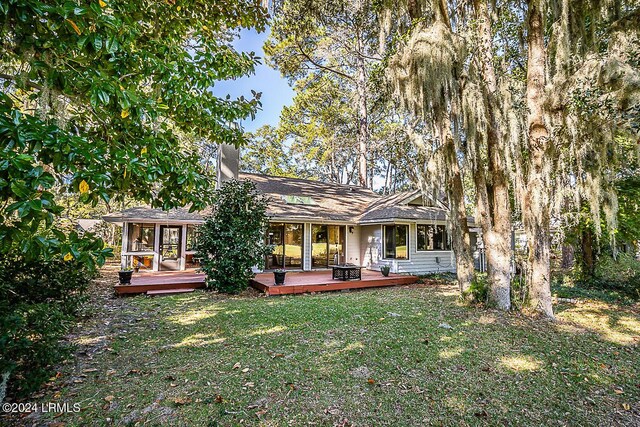 rear view of house featuring a yard and a deck