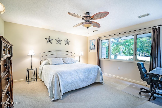 carpeted bedroom featuring a textured ceiling and ceiling fan