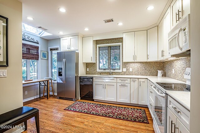 kitchen featuring sink, white appliances, white cabinets, and light wood-type flooring