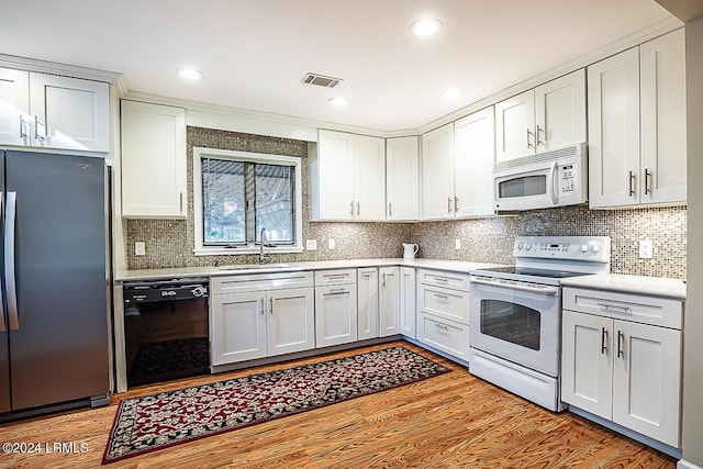 kitchen featuring sink, white appliances, and white cabinets