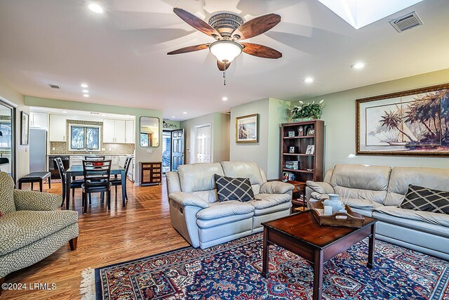 living room featuring light hardwood / wood-style floors and ceiling fan