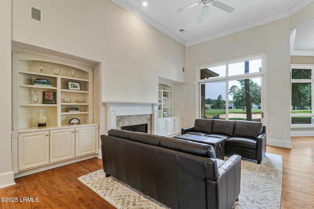 45 Manchester Ct, Bluffton, SC 29910 - living room featuring crown molding, ceiling fan, built in shelves, a high ceiling, and a fireplace