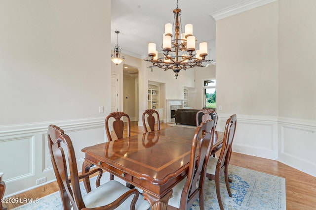 45 Manchester Ct, Bluffton, SC 29910 - dining space featuring a chandelier, light wood-style floors, ornamental molding, a decorative wall, and a wainscoted wall