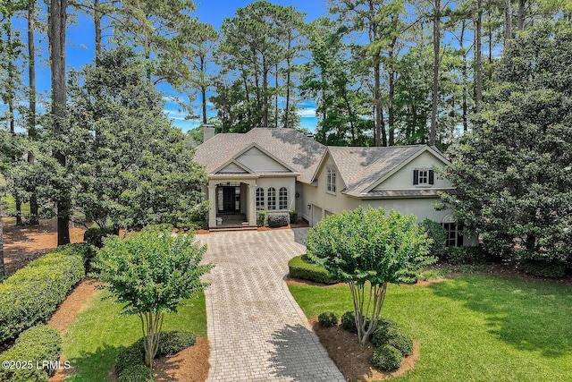 45 Manchester Ct, Bluffton, SC 29910 - view of front of property featuring stucco siding, a garage, a chimney, decorative driveway, and a front yard