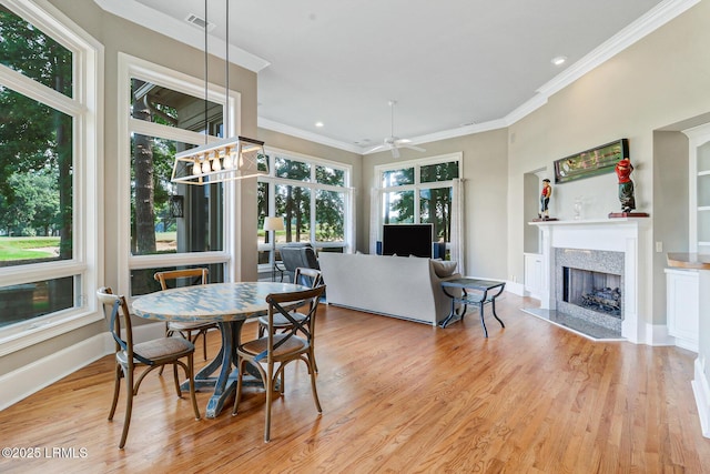 45 Manchester Ct, Bluffton, SC 29910 - dining area featuring a fireplace, crown molding, a ceiling fan, wood finished floors, and baseboards