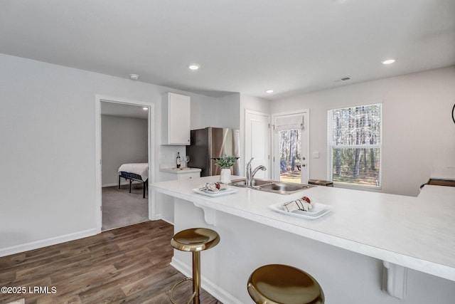 580 Rudy Dr, Hardeeville, SC 29927 - kitchen with light countertops, white cabinets, a sink, a kitchen breakfast bar, and freestanding refrigerator