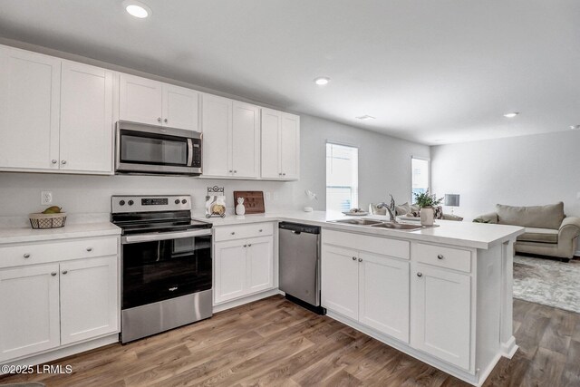 580 Rudy Dr, Hardeeville, SC 29927 - kitchen featuring open floor plan, a sink, white cabinets, a peninsula, and appliances with stainless steel finishes