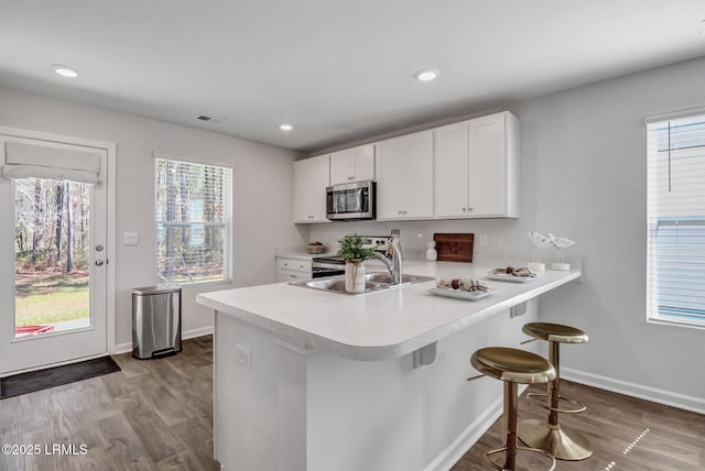 580 Rudy Dr, Hardeeville, SC 29927 - kitchen featuring light countertops, wood finished floors, white cabinets, and stainless steel microwave