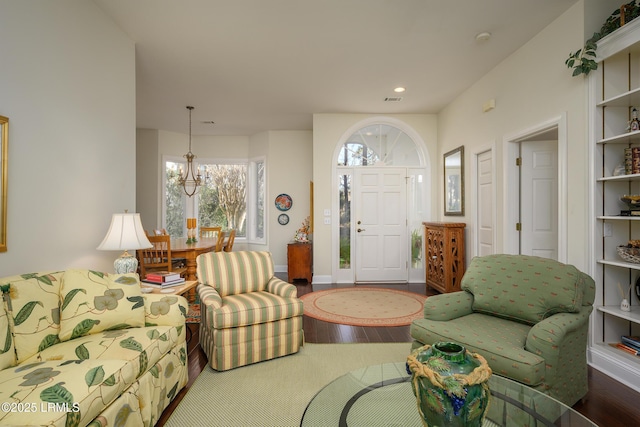 living room with hardwood / wood-style flooring and a notable chandelier