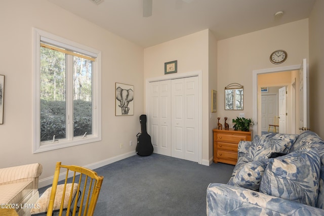 sitting room featuring dark colored carpet and ceiling fan