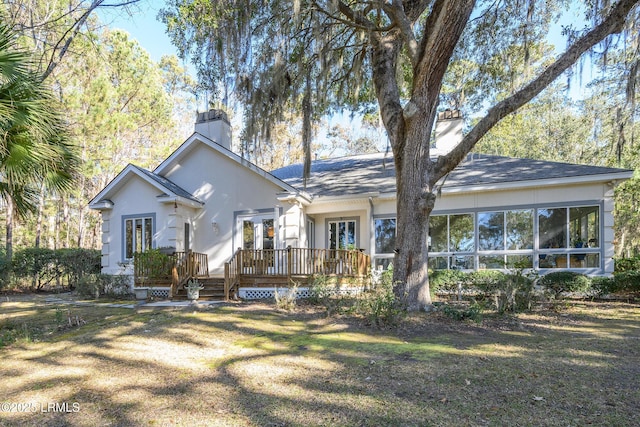 single story home with a wooden deck, a sunroom, and a front lawn