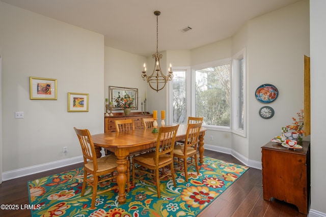 dining room with an inviting chandelier and dark hardwood / wood-style floors