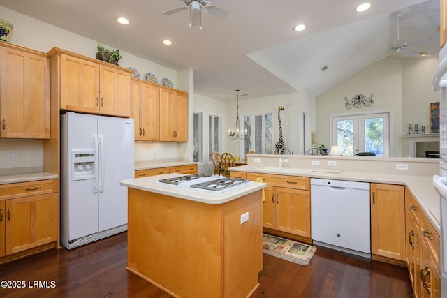 kitchen with pendant lighting, white appliances, a kitchen island, ceiling fan with notable chandelier, and kitchen peninsula