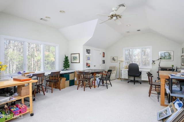 office featuring a healthy amount of sunlight, vaulted ceiling, and light carpet