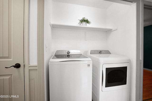 laundry area with hardwood / wood-style floors and washer and dryer