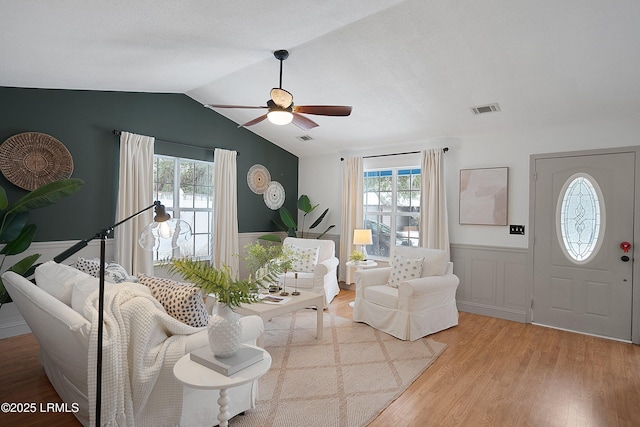 living room featuring lofted ceiling, a wealth of natural light, ceiling fan, and light hardwood / wood-style flooring