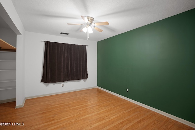 unfurnished room featuring a textured ceiling, light hardwood / wood-style flooring, and ceiling fan