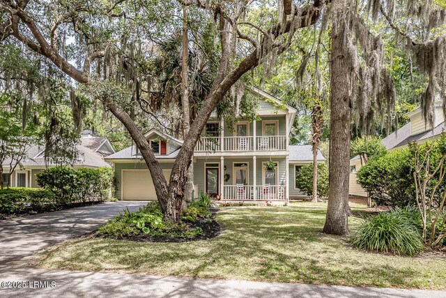 459 Bb Sams Dr, Saint Helena Island, SC 29920 - view of property hidden behind natural elements featuring covered porch, aphalt driveway, a garage, a balcony, and a front lawn