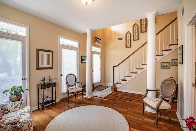 459 Bb Sams Dr, Saint Helena Island, SC 29920 - entrance foyer with visible vents, ornate columns, wood finished floors, and a healthy amount of sunlight