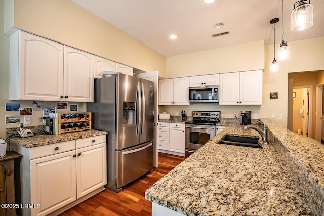 459 Bb Sams Dr, Saint Helena Island, SC 29920 - kitchen featuring dark wood-style floors, a sink, a peninsula, light stone counters, and appliances with stainless steel finishes
