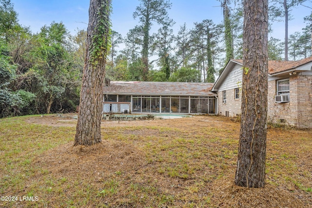 back of property featuring cooling unit, a yard, and a sunroom