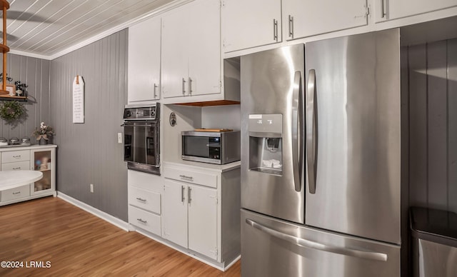 kitchen with white cabinetry, wine cooler, stainless steel appliances, crown molding, and light wood-type flooring