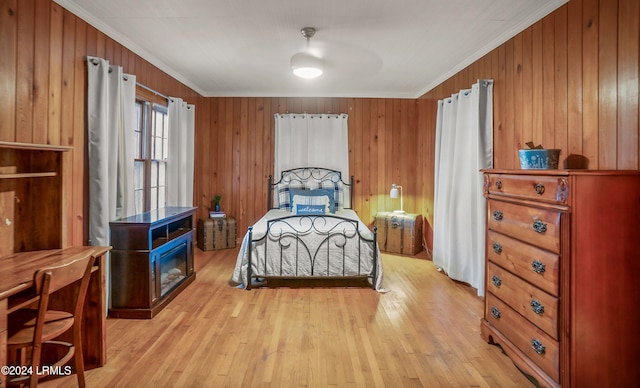 bedroom with light hardwood / wood-style flooring, ornamental molding, and wooden walls