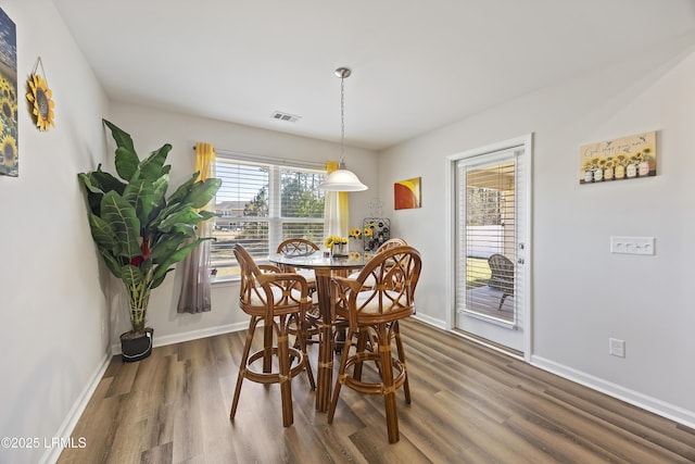 dining space featuring visible vents, baseboards, and wood finished floors