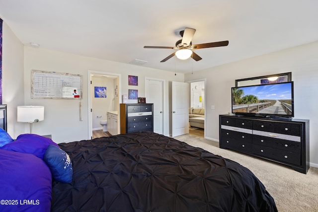 carpeted bedroom featuring visible vents, baseboards, ensuite bathroom, and ceiling fan