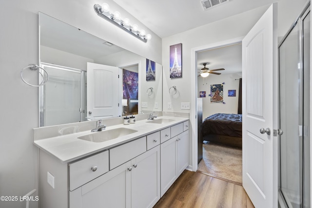 ensuite bathroom with visible vents, a stall shower, ensuite bathroom, and a sink