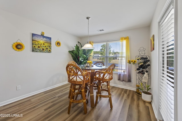 dining area featuring dark wood finished floors, visible vents, and baseboards