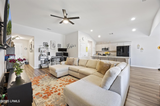 living room featuring recessed lighting, visible vents, wood finished floors, and vaulted ceiling