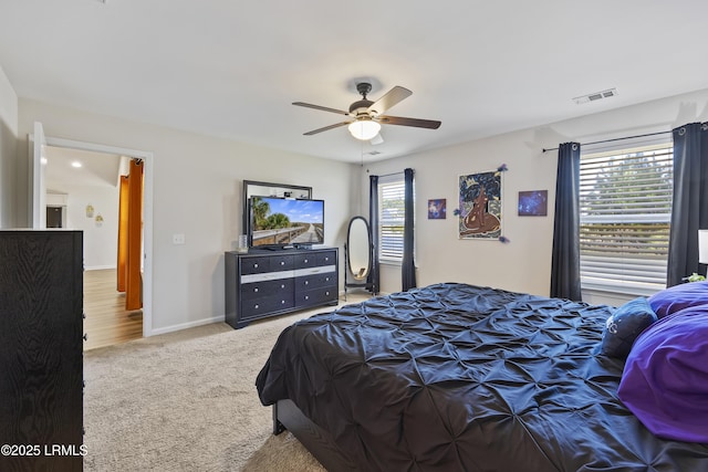 carpeted bedroom with baseboards, visible vents, and ceiling fan