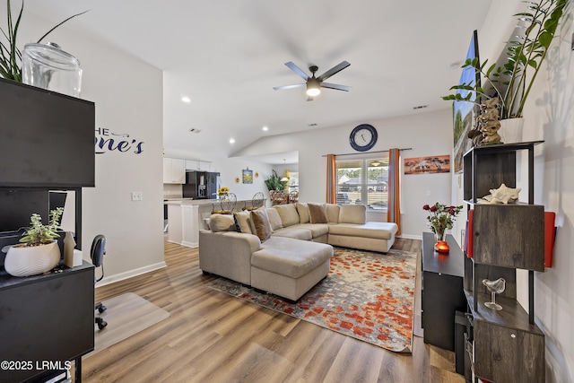 living room with a ceiling fan, baseboards, lofted ceiling, light wood-style flooring, and recessed lighting