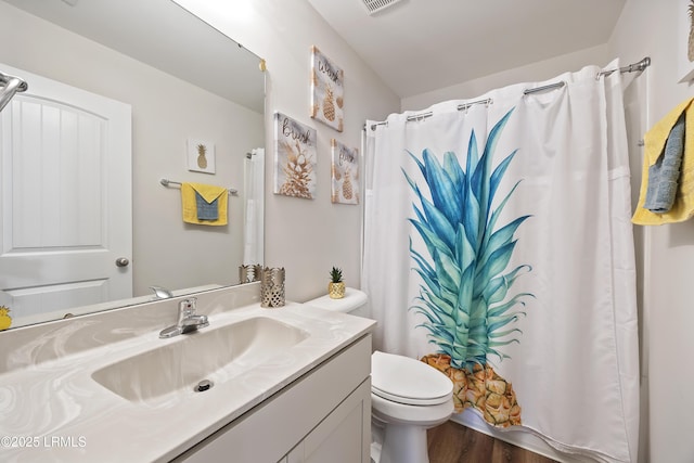 bathroom with toilet, vanity, a shower with curtain, and wood finished floors