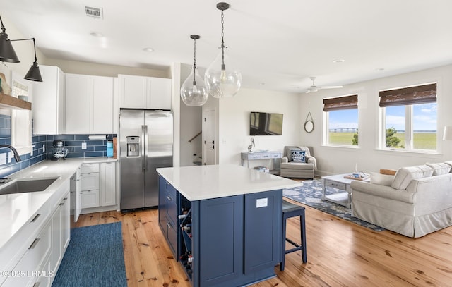 18 Sand Dollar Ct, Harbor Island, SC 29920 - kitchen with sink, blue cabinetry, white cabinetry, stainless steel appliances, and a center island