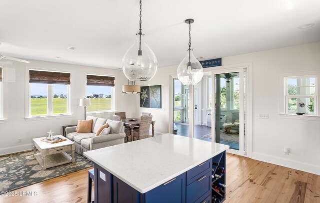 18 Sand Dollar Ct, Harbor Island, SC 29920 - kitchen featuring blue cabinetry, a breakfast bar, light wood-type flooring, and pendant lighting
