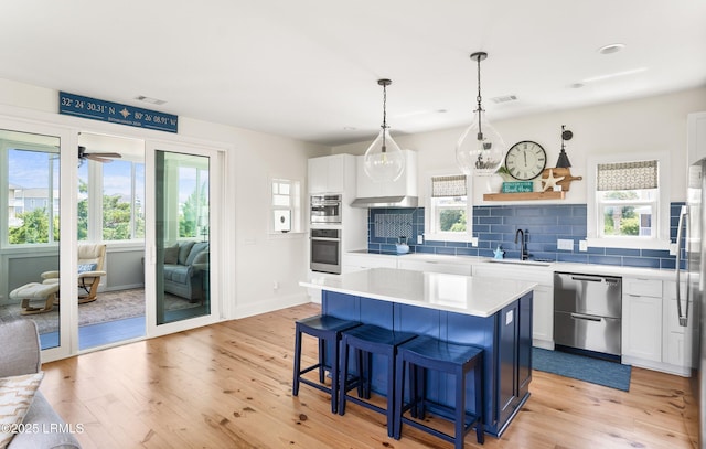 18 Sand Dollar Ct, Harbor Island, SC 29920 - kitchen featuring stainless steel appliances, white cabinetry, a center island, and light wood-type flooring