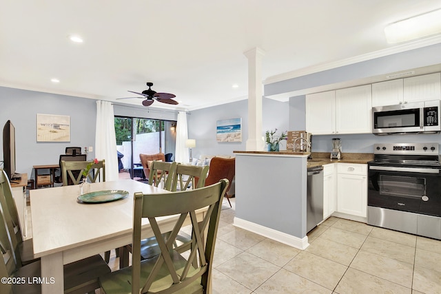 kitchen featuring light tile patterned floors, crown molding, appliances with stainless steel finishes, white cabinets, and kitchen peninsula