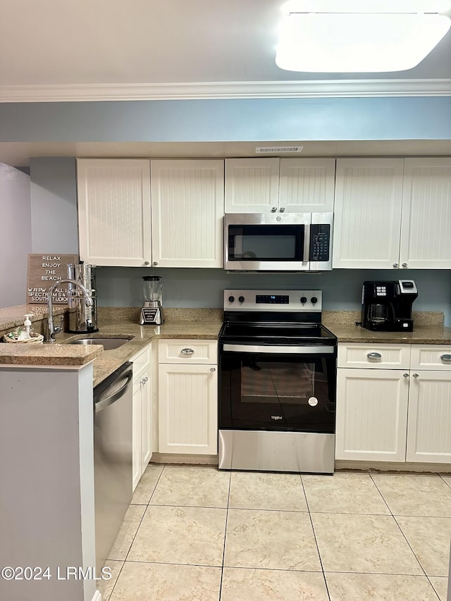 kitchen with sink, crown molding, light tile patterned floors, appliances with stainless steel finishes, and light stone countertops