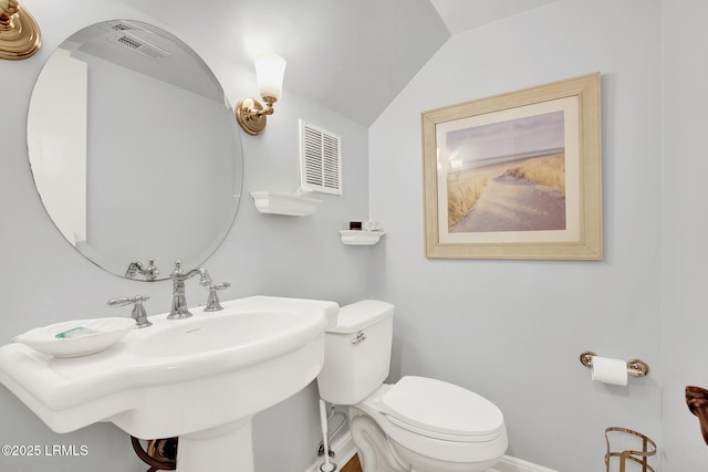 bathroom featuring lofted ceiling, toilet, and sink