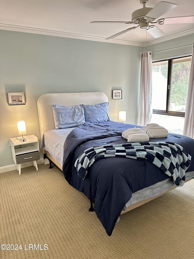 carpeted bedroom with ornamental molding and ceiling fan