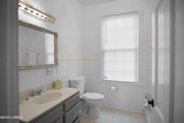 bathroom with tile walls, vanity, tile patterned floors, and toilet