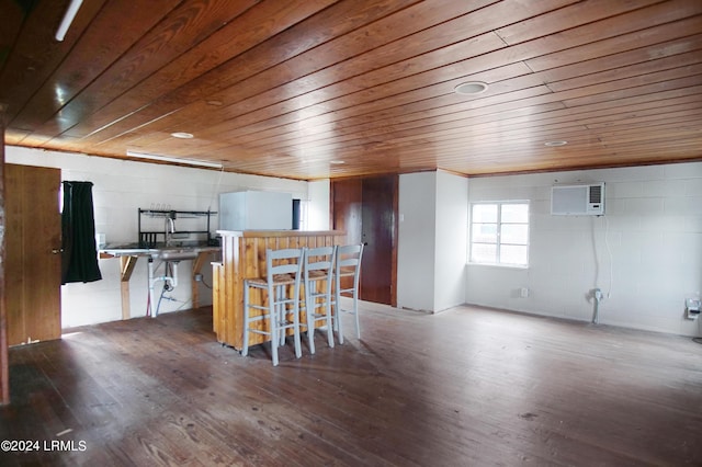 kitchen featuring hardwood / wood-style flooring, a wall mounted air conditioner, a breakfast bar area, and wood ceiling