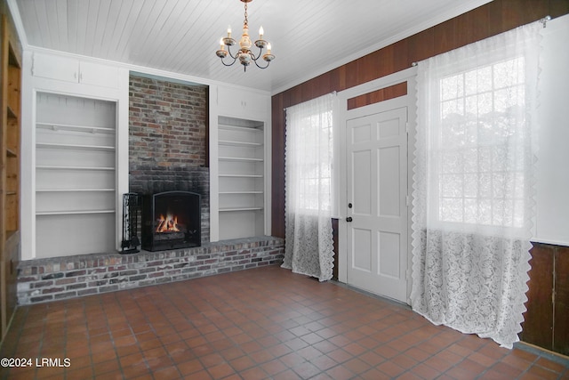 foyer entrance featuring a brick fireplace, plenty of natural light, ornamental molding, and wood walls