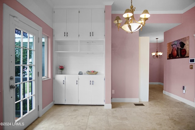 kitchen with pendant lighting, light tile patterned floors, crown molding, white cabinetry, and an inviting chandelier