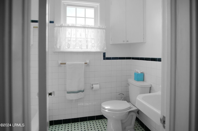 bathroom featuring tile walls, sink, and toilet