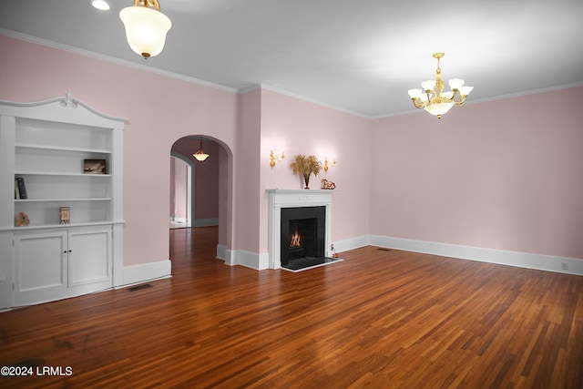 unfurnished living room with hardwood / wood-style floors, built in shelves, and ornamental molding