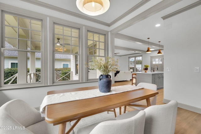 dining area featuring beam ceiling, crown molding, recessed lighting, light wood-style floors, and baseboards